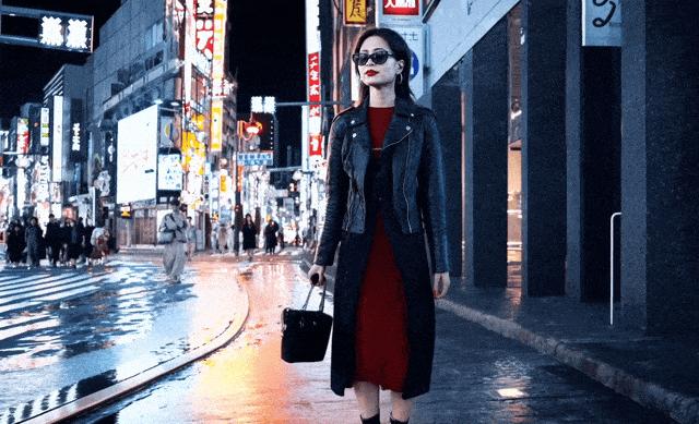 OpenAI公布的其中一部范例视频是,一名身穿深蓝色夹克和红色连身裙的女子走在东京繁华街道上。虽然背景文字明显不是日文,但女人行走的风范、环境和色彩的渲染度都让人难以找出破绽。(视频截屏)