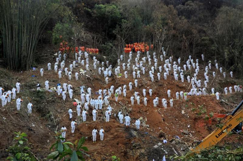 2022年3月27日,搜救人员在东航MU5735航班坠机现场默哀。(路透社)