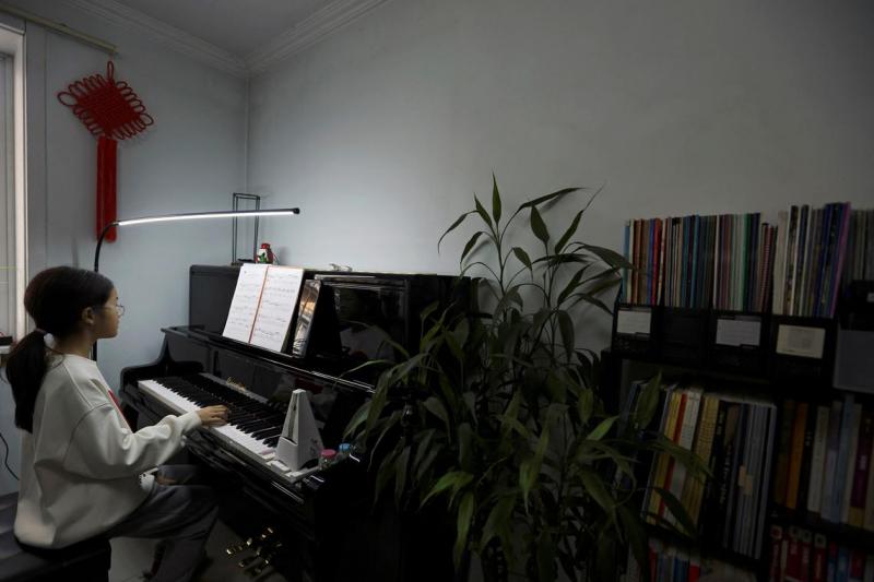 不少中国中产家庭认为,让孩子上钢琴课显得高档次、有面子。图为北京一名学生3月12日在教室里上钢琴课。(路透社)