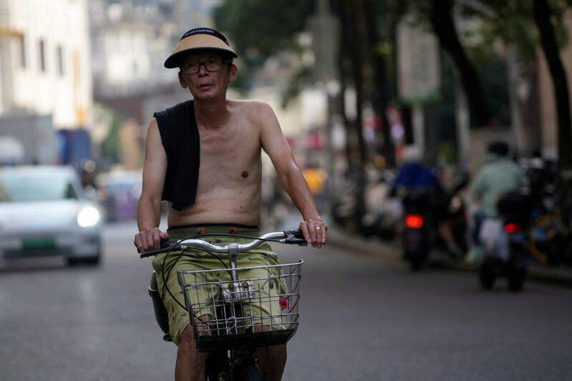 一名没有穿上衣的年长男子,7月11日在上海街头骑着脚踏车。(路透社)