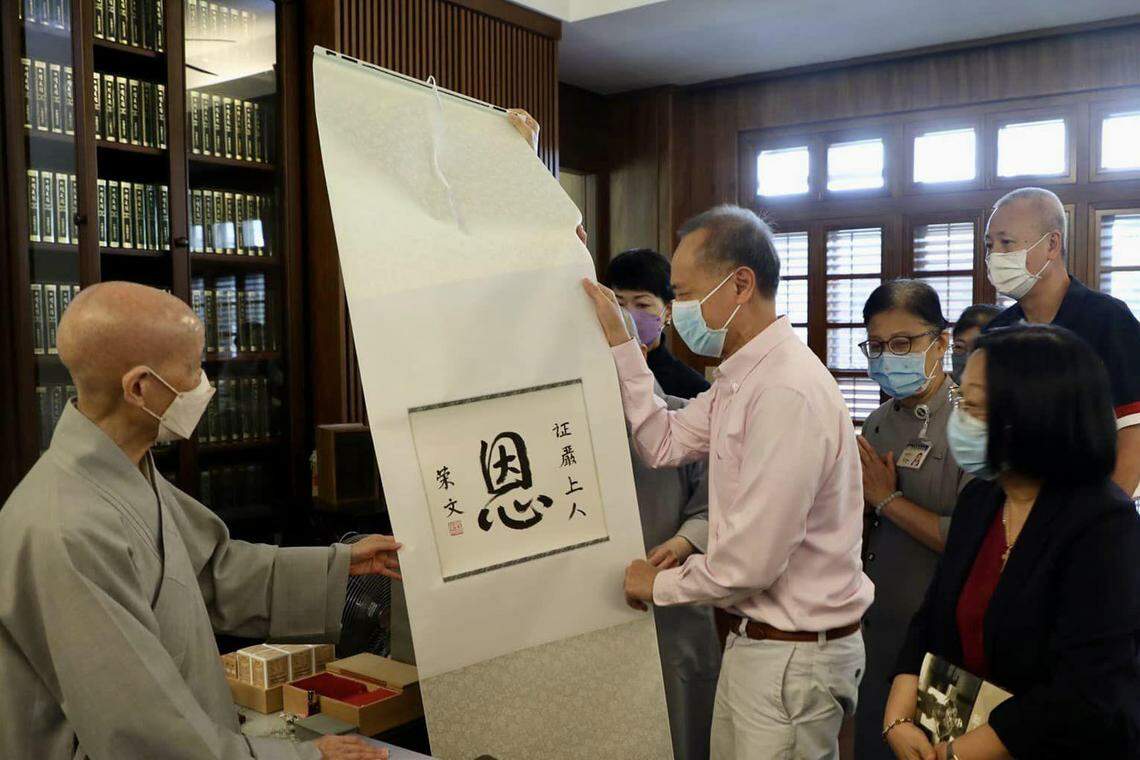 杨荣文(前排中)星期一(9月11日)携太太梁利平(前排右)和小儿子杨时弘到花莲慈济静思精舍,向证严法师(左)送上他的亲笔书法,以“恩”字表达对慈济牵线为杨时弘找到骨髓捐献者的感激。(杨荣文脸书)