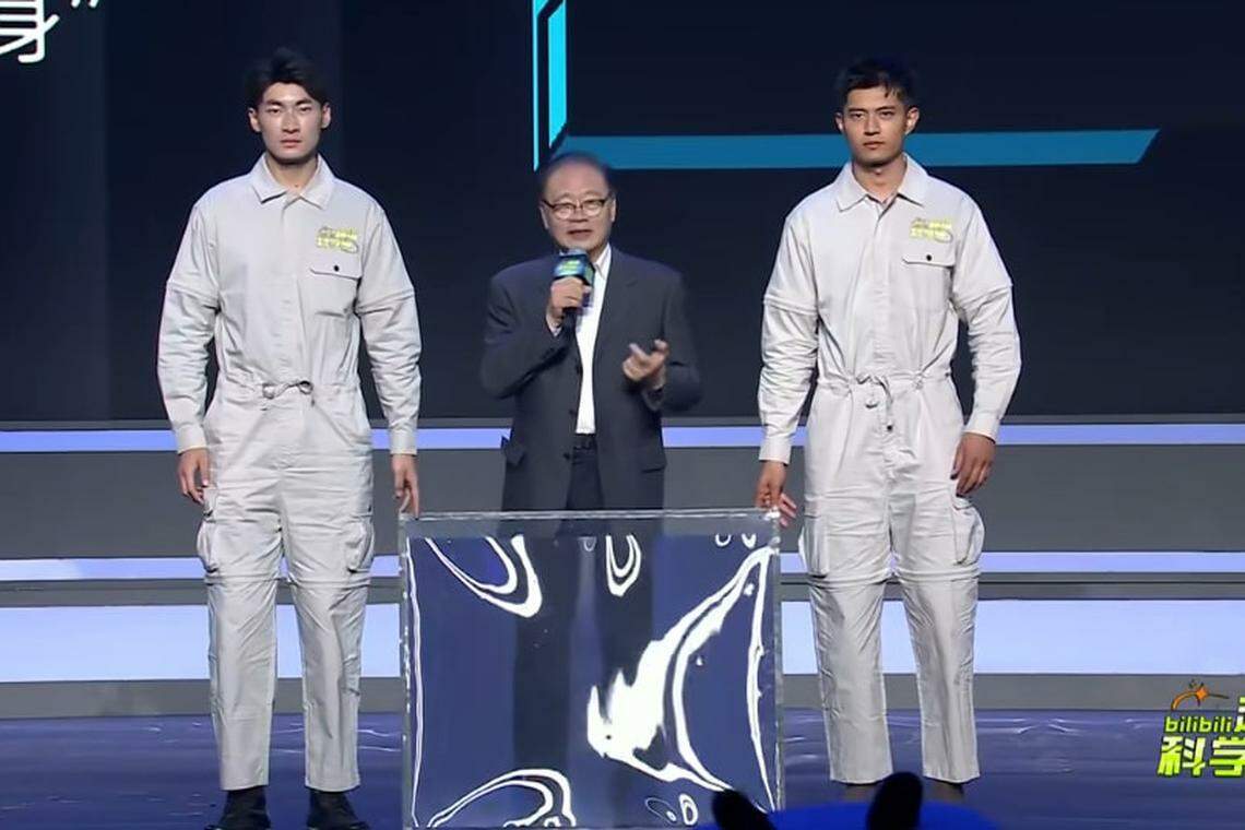 褚君浩(中)还没展示“隐身术”前,两名工作人员手持一块面板站在他身旁。(哔哩哔哩视频)