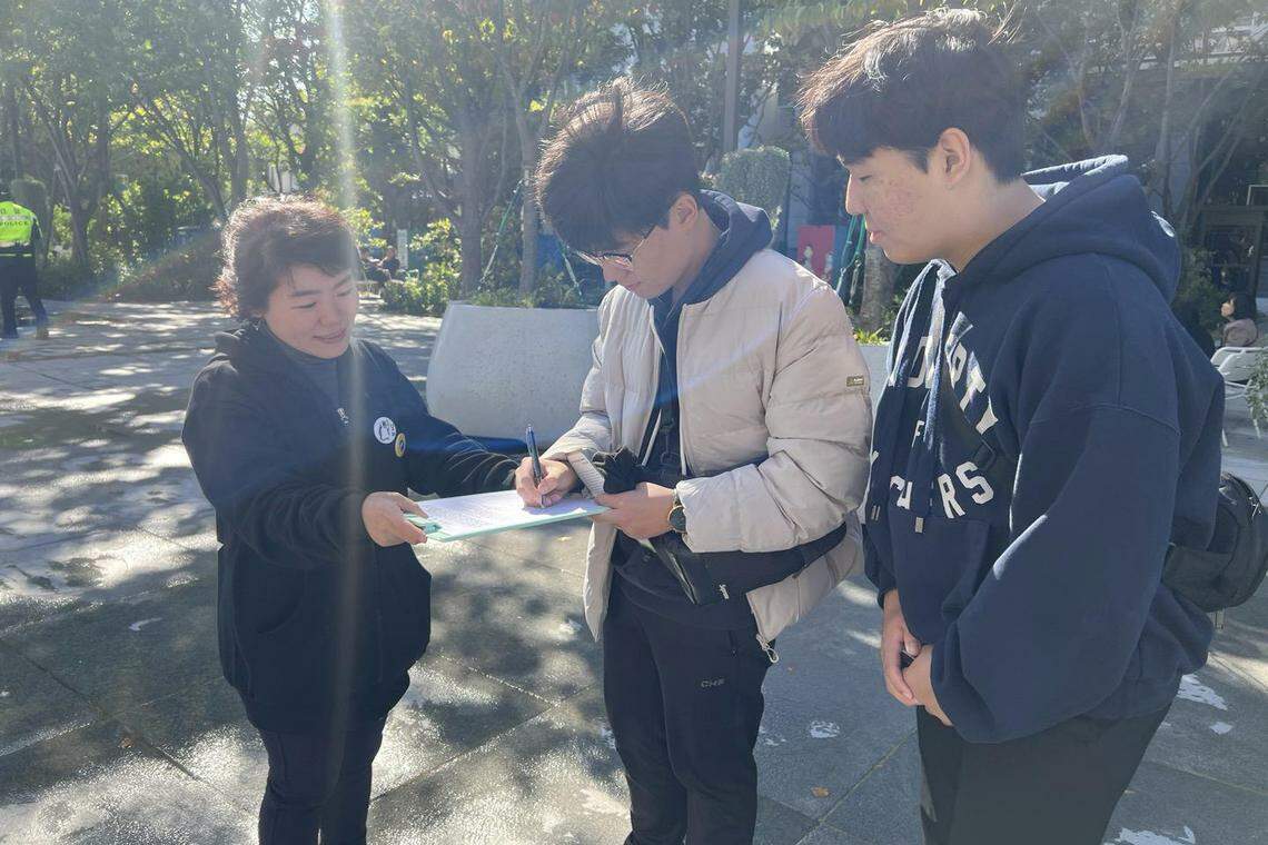 韩国教师走上街头收集公众签名,希望能获100万人签名支持修改《儿童福利法》。(姜贵瑛摄)