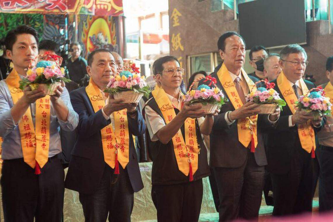 柯文哲(右一)与郭台铭(右二)站在一起,与侯友宜(左二)中间隔着台北葫芦寺董事长郭江源(中)。他们三人11月2日出席葫芦寺举办的宗教仪式。(法新社)