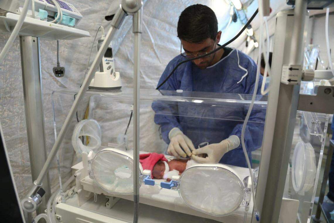加沙战火重燃,局势再次紧张。在加沙的约旦野战医院内,医护人员细心照顾保温箱里的一名早产儿。(路透社)