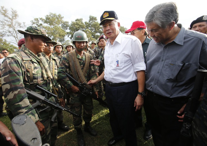 2013年3月7日,马国时任首相纳吉(右二)及时任国防部长阿末扎希(右一)在甘榜丹道附近与马国士兵见面。纳吉拒绝苏禄军提出的停火建议,并要求对方无条件投降。(路透社档案照片)