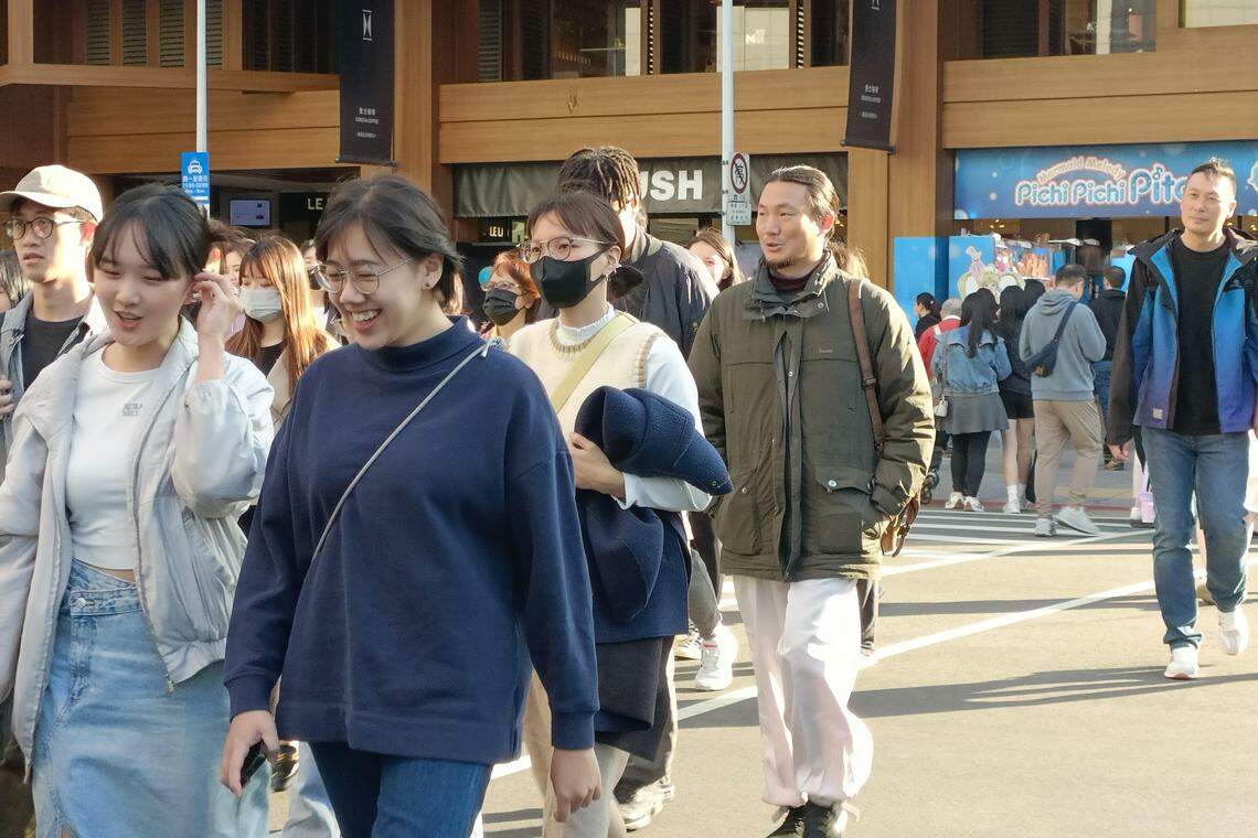 相对于两岸议题,受访台湾年轻人更在意生活安全、公平正义、低薪高房价等切身议题。图为1月2日台北信义区街头的年轻人。(温伟中摄)