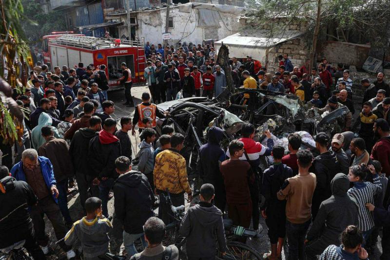 加沙南部城市拉法星期一遭受空袭,一辆汽车被击毁,事后现场聚集许多巴勒斯坦民防人员和围观民众。有报道称,这辆汽车被以色列无人机瞄准,车上三人全部死亡。(法新社)