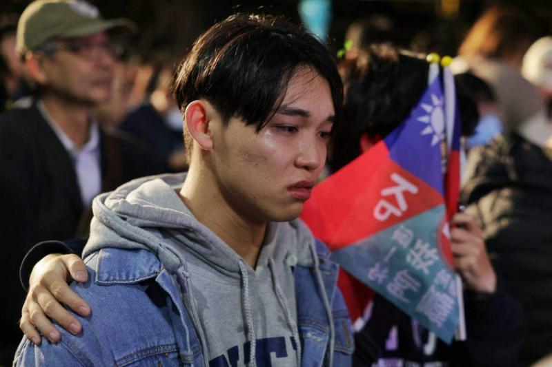 柯文哲的得票率在开票后持续落后,在民众党竞选总部等候选举成绩的一名年轻支持者伤心落泪。(法新社)