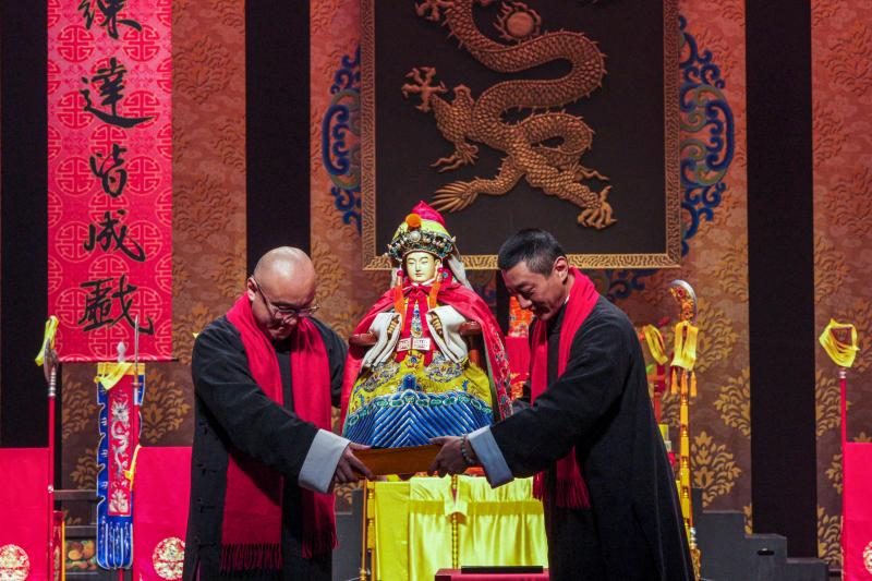 国光剧团两名成员2月15日抬起祖师爷塑像恭迎回銮。(法新社)