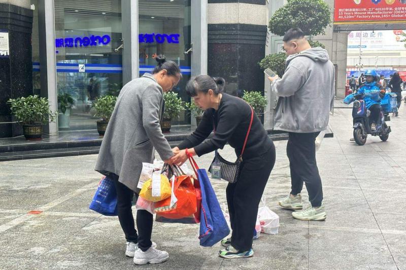 代送阿姨私下交换订单,集中相近楼层的外卖,让派送工作更高效。(林煇智摄)