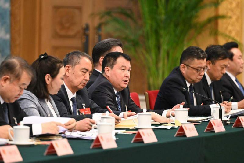 新疆人大代表团星期四(3月7日)举行开放团组会议,审议政府工作报告并回答记者提问。 图为全国人大代表地力下提·帕尔哈提(左四)答记者问。
