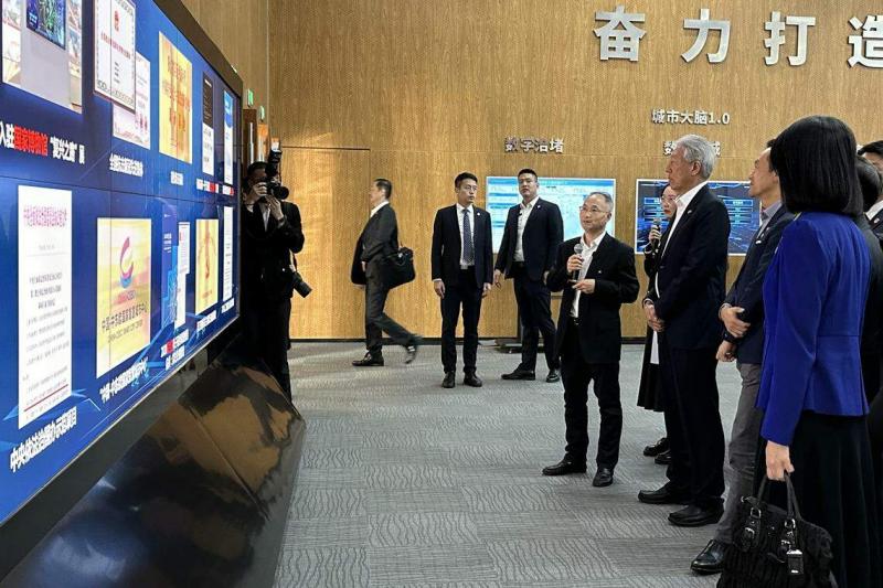 杭州市政府副秘书长、市数据资源管理局长徐青山(右四)向国务资政兼国家安全统筹部长张志贤(右三)介绍杭州城市大脑系统。(陈婧摄)