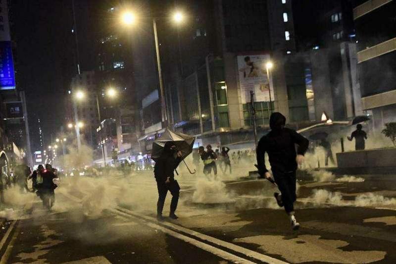 2019年香港爆发反修例运动。图为当年12月25日凌晨12时左右,有激进示威者向警车投掷燃烧瓶,并在附近的汇丰银行进行破坏及纵火,警方施放催泪弹驱散。(中通社)