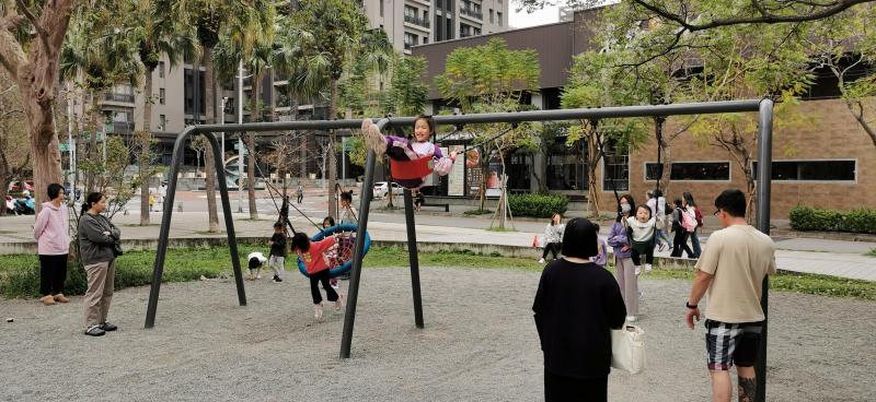 离新竹科学园区两公里的关新公园,许多家长带小孩荡秋千。关新里的面积不到0.2平方公里,九成住户在竹科上班,平均年龄35岁以下,14岁以下儿童占29%。(温伟中摄)