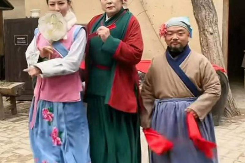 “王婆说媒”本是开封万岁山武侠城景区一档为了让游客感受大宋开封的市井文化的节目。图为王婆(中)和潘金莲(左)和武大郎(右)的饰演者合照。(互联网)