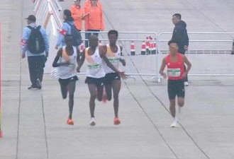 网传视频显示,三名非洲选手并排跑时,中间的选手突然伸出手来,似乎在阻拦身旁的另一名选手。(互联网)