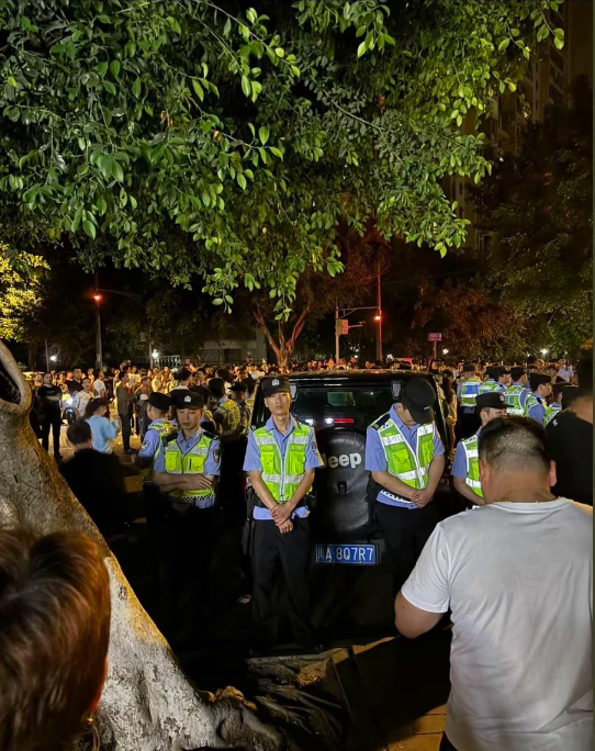 冲突发生后,成都警方围着涉事的黑色吉普越野车,不让民众靠近。(互联网)