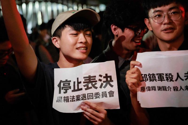 台湾蓝绿立委在立法院爆发肢体冲突后,有民众星期五晚到立法院集会,抗议立法院表决议程透明度不足,要求立法院停止表决。有民众举着标语,写道“停止表决 黑箱法案退回委员会”。(法新社)