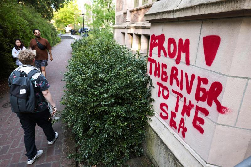 5月12日,华盛顿大学校园内抗议大学与以色列关系的示威者营地附近出现涂鸦,石墙被喷上“从河流到海洋”的字眼。(法新社)