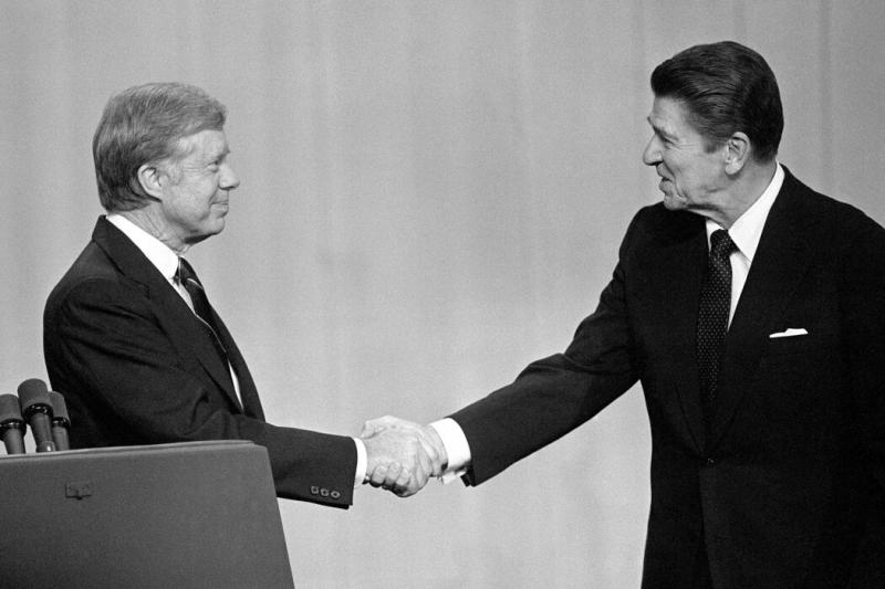 卡特总统(左)和加利福尼亚州州长里根在1980年的最后一场辩论中出现了一个令人难忘的时刻。里根在回应卡特的长篇大论时说了一句现在很有名的话 “你看你又来了”。