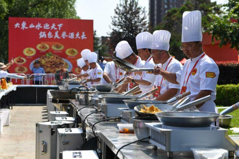 专业厨师6月29日在世界锅包肉大赛现场展示锅包肉制作过程。(新华社)