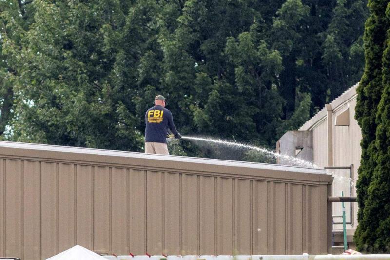 7月13日,克鲁克斯在距离特朗普约100米的三点钟方向埋伏。图为案发后,联邦调查局人员屋顶上清洗血迹。(路透社)