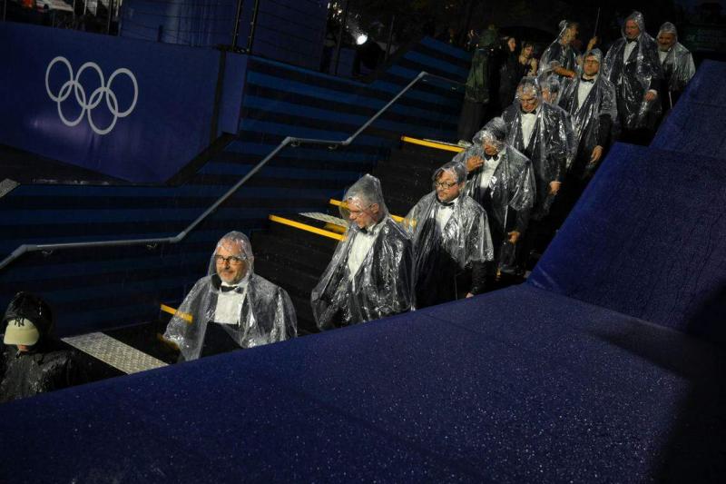 表演者身穿雨衣,准备上台表演。(海峡时报)