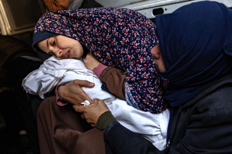 3月,在加沙南部城市拉法的一家医院外,一位母亲抱着已死去的双胞胎。