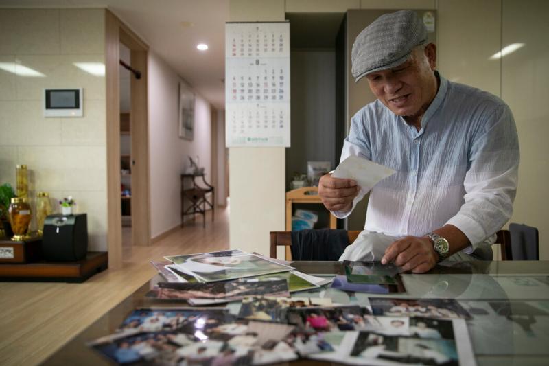 1998年,朴采书的情报特工身份被曝光,结束了他的卧底生涯,图中朴在潮正在翻看他在朝鲜担任间谍时的照片。