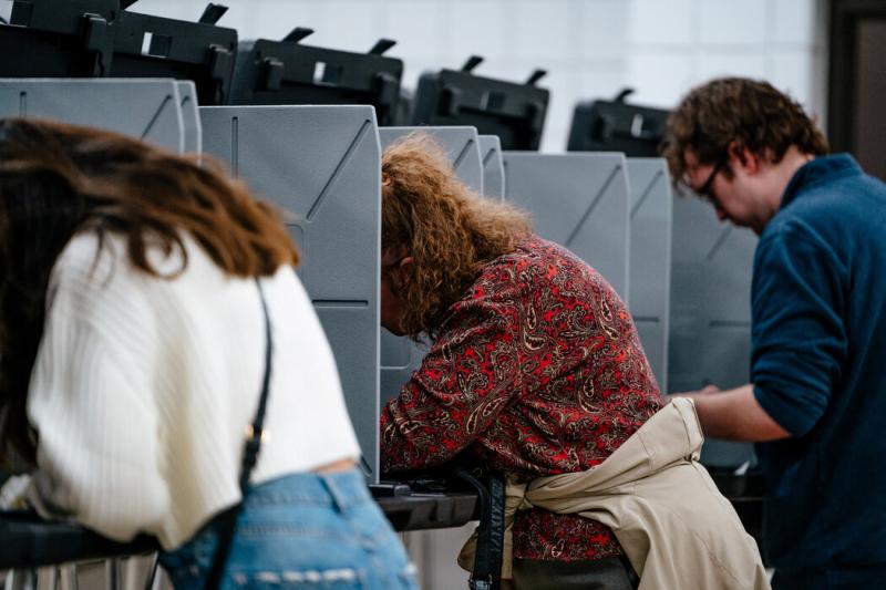 周日,在密歇根州诺维市,提前投票的选民在诺维市政中心填写选票。