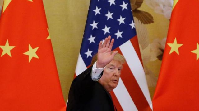 特朗普在中美国旗之间挥手。