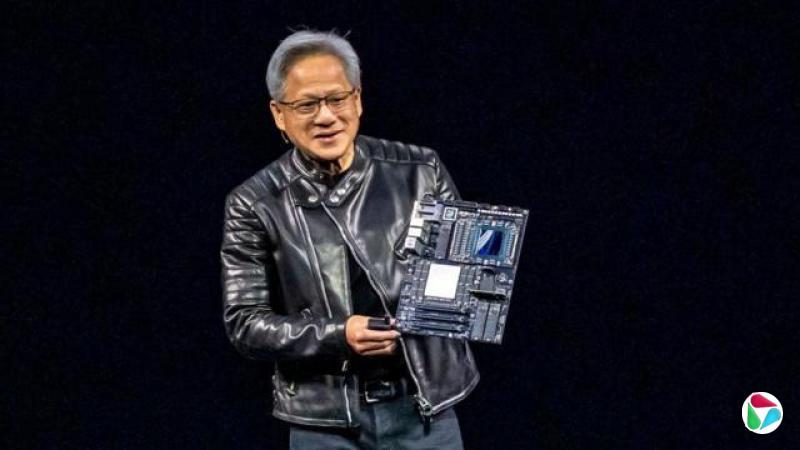 穿着黑色皮衣与牛仔裤的黄仁勋站在舞台上,手中拿着一块电路板。