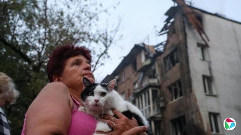 一名女子在基辅一栋于7月10日遭俄罗斯炮弹击中的建筑前抱着一只猫