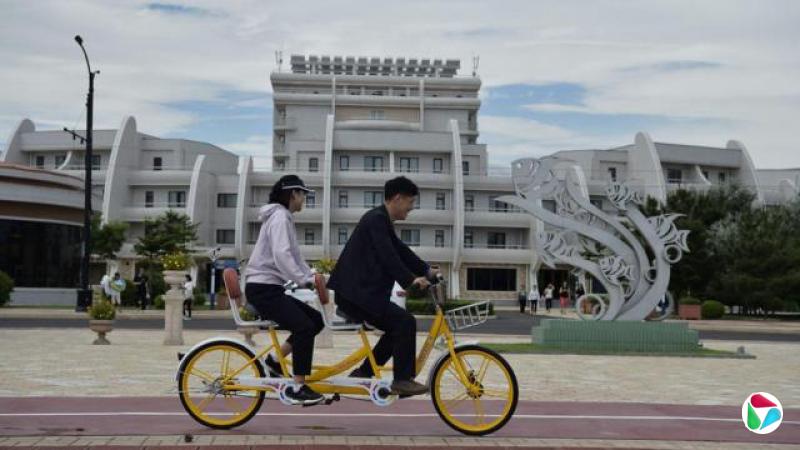 海滨酒店的建设速度极快,引发了人们对建筑工人工作条件的担忧。图为朝鲜江原道(Kangwon Province)元山市的元山葛麻沿海旅游区(Wonsan Kalma Coastal Tourist Area),境内游客正在骑自行车。