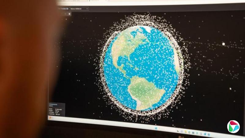 一名士兵注视着萤幕,萤幕上显示着绕地球运行的卫星。