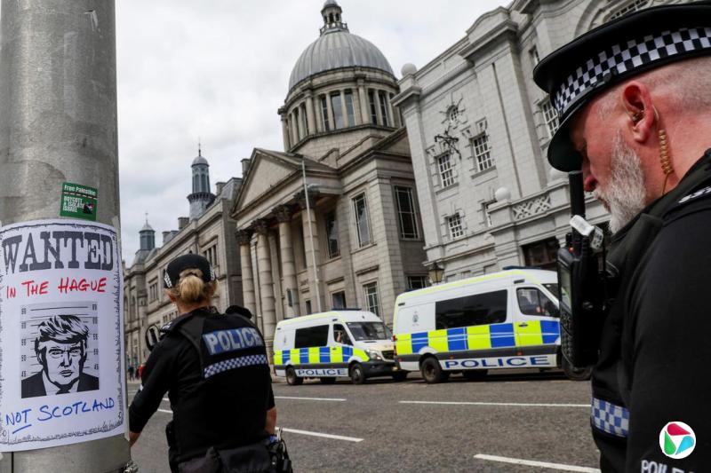 英国苏格兰阿伯丁警方出动大批警力,到示威现场维持秩序。其中一个柱子被示威者贴上通缉特朗普的告示。(路透社)
