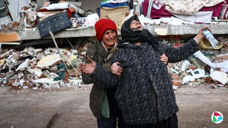 在土耳其卡赫拉曼马拉什省埃尔比斯坦区,一场强烈地震过后,妇女们在一栋倒塌建筑的现场作出反应