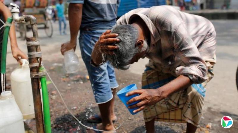 孟加拉达卡,一名男子在酷热中向头上泼水。