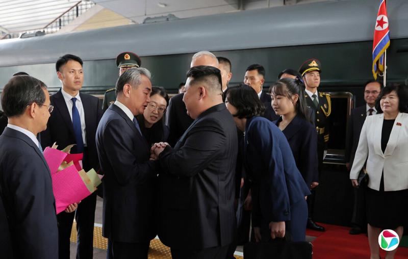 朝鲜官方媒体周二发布的这张照片显示,中国外交部长王毅前往迎接到访的金正恩。右侧为金正恩的女儿。