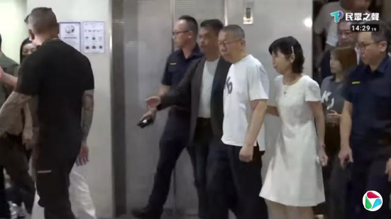 柯文哲身穿印有“KP”字样的白色T恤步出台北地方法院,其妻子陈佩琪陪同在侧。