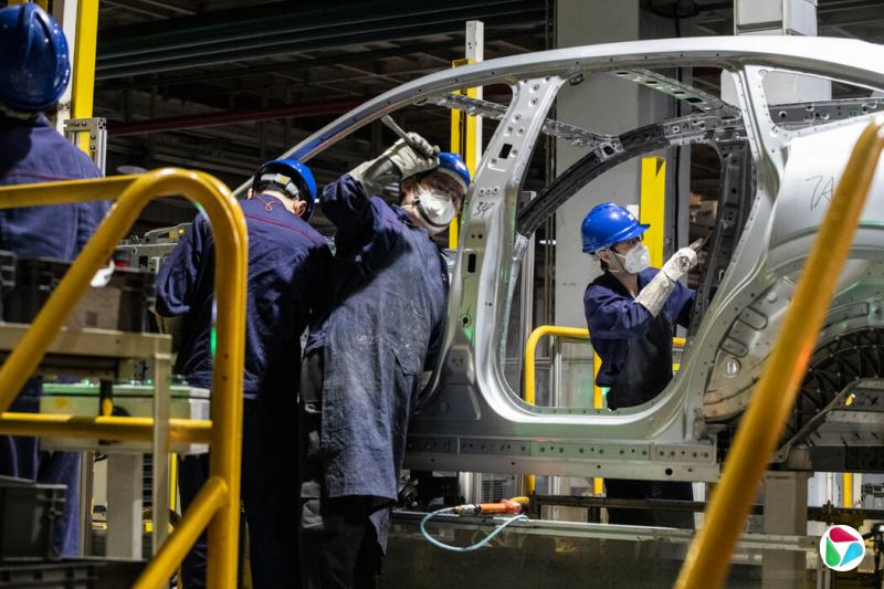 电动汽车工厂生产线上的工人。