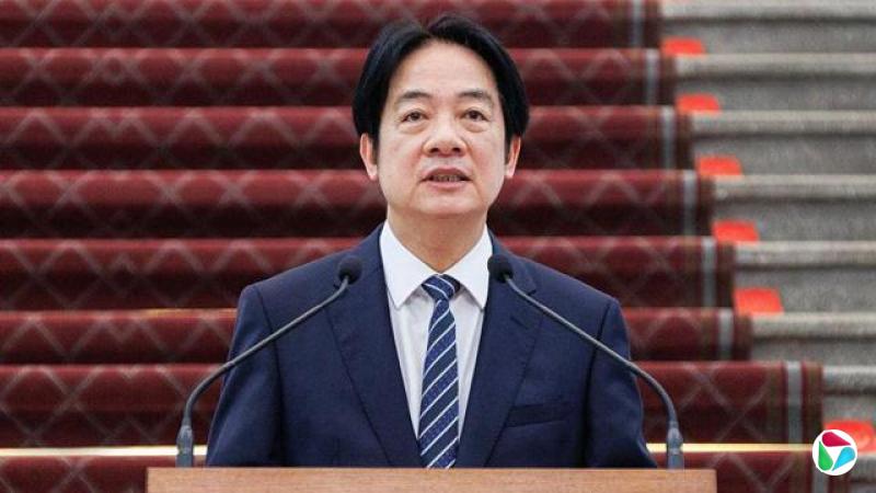 台湾赖清德身穿深蓝色西装,系着条纹领带,站在麦克风前。