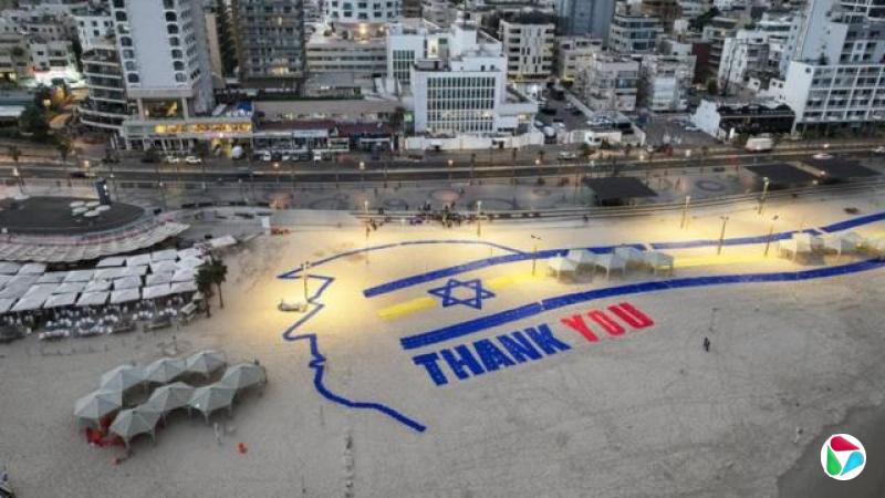 特拉维夫海滩上竖立着一块巨大的标牌,上面用蓝色和红色写着“谢谢”,还有一面以色列国旗,以及美国总统唐纳德·特朗普的头像轮廓