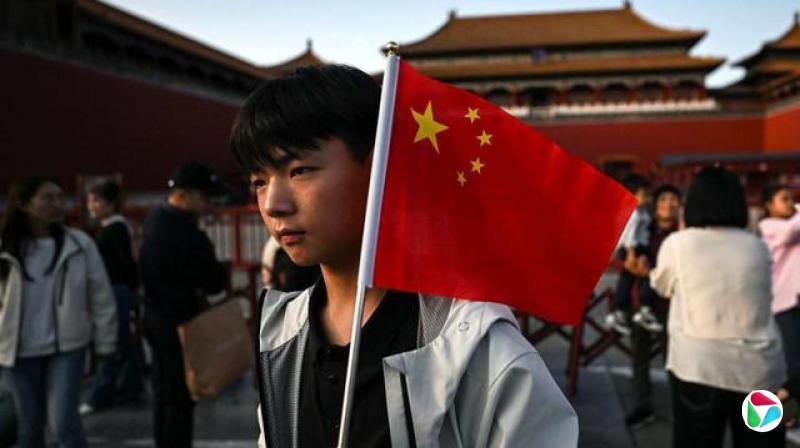 中国国庆黄金周假期期间,一名男子在北京故宫前举着国旗