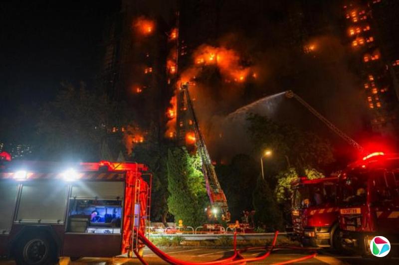 消防表示,目前有两、三座大楼仍严峻,现场温度高。图中有两架消防车停泊,架起钢梯向大厦射水。